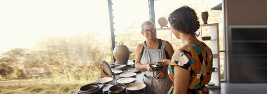 Woman shopping for pottery with Unitus credit card