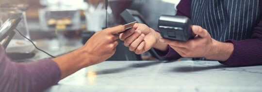 Customer handing merchant a chip card for payment