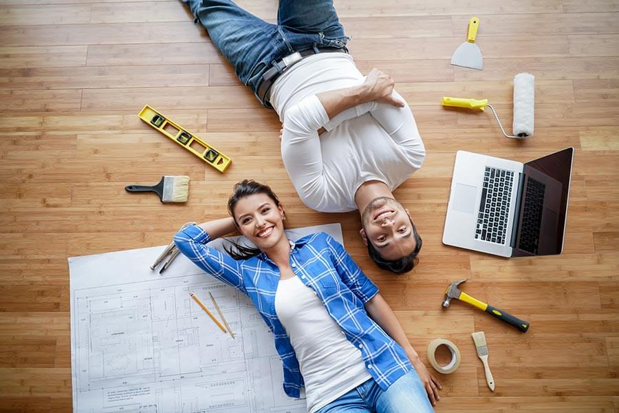 Portrait of a happy Latin American couple working on a housing project surrounded by tools and looking at the camera.