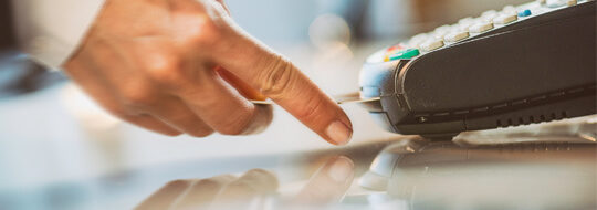 Hand inserting chip card into a retailer's chip card reader