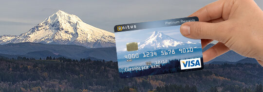 Hand holding customized Unitus business credit card with Mt. Hood pictured on the card