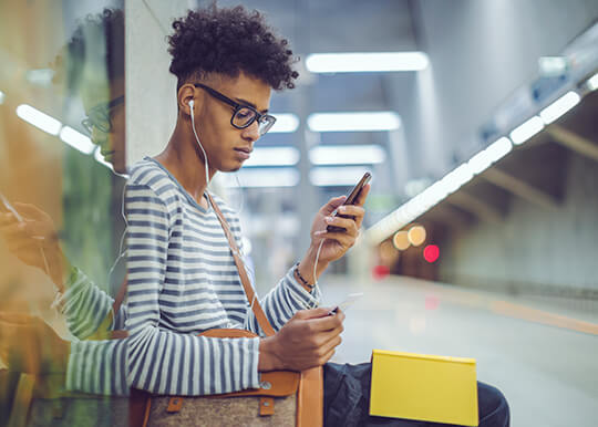 man using credit card and mobile phone to make a purchase