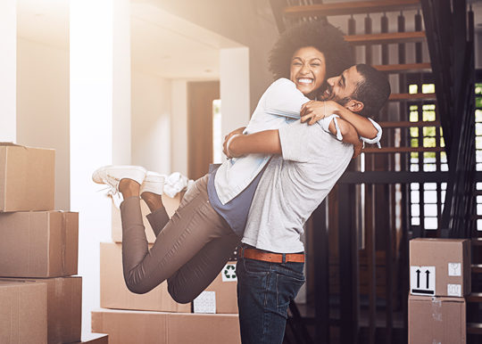 young woman jumping into arms of male, first time homeowners