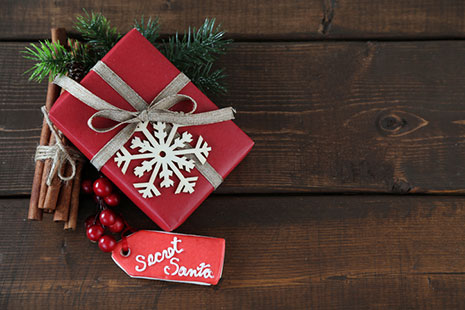 Consejos para las compras navideñas: Un regalo envuelto en rojo con cinta plateada.