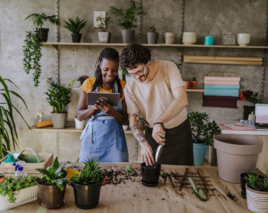 Two florists using a digital tablet in plant shop.