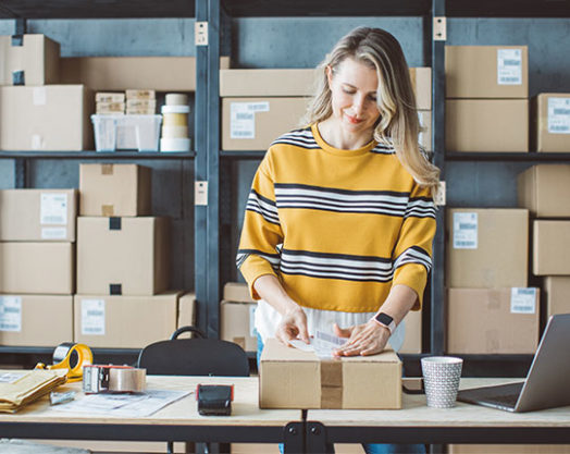 Propietaria de pequeña tienda online. Recepción de pedidos y embalaje de cajas para su entrega.