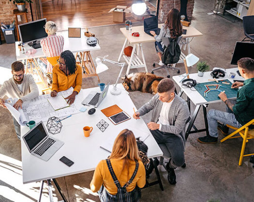 Businessman and businesswoman analyzing blueprint of new project at office