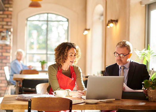 Small business loan expert meeting with a business owner in her cafe.