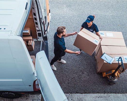 Delivery workers using a Hydraulic Hand Pallet Truck to load a delivery van.