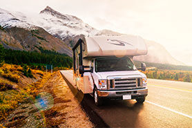 Large RV on a scenic mountain road.