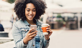 Mujer realizando un pago en línea utilizando su teléfono.