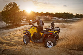 Carreras de arena en quad todoterreno al atardecer.