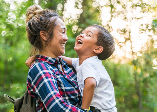 mother and son laughing on a hike