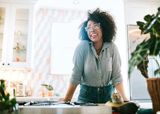 A happy woman enjoys time at her new home, relaxing and basking in the enjoyment of her newly designed space.