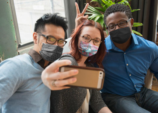 Co-workers wearing mask and taking selfie