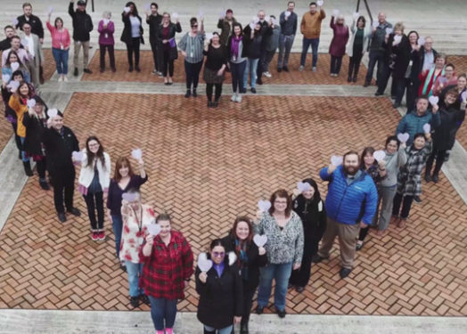 Unitus employees standing in the shape of a heart