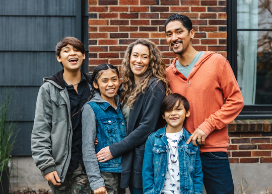 family standing in front of home
