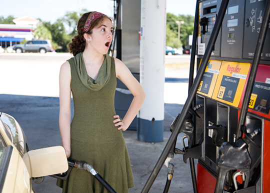 woman pumping gas with look of shock on her face
