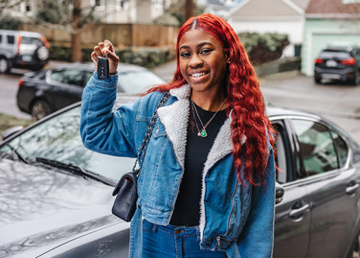 mujer joven con las llaves de un coche nuevo