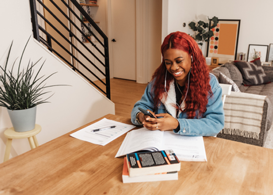 joven afroamericana estudiando en la mesa del comedor