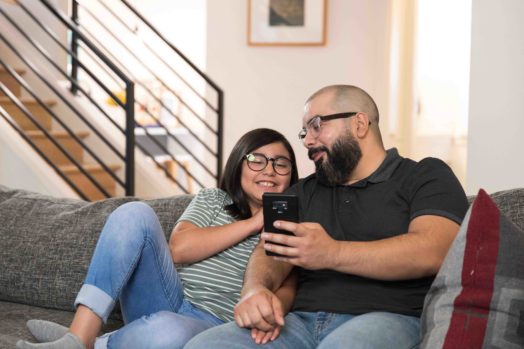 father and daughter on sofa with mobile phone