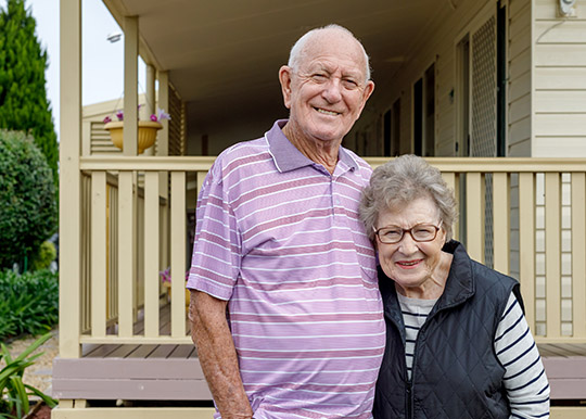 Older couple in front of house