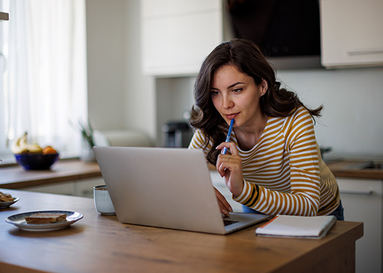 Woman on laptop in kitchen